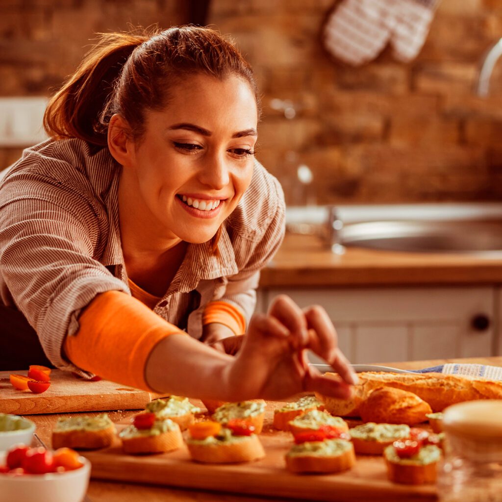 Mulher sorridente beliscando uma deliciosa receita feita com produtos da Seara Food Solutions.|Diagrama com todas as marcas de Food Service, ou Food Solution, do mercado atual.